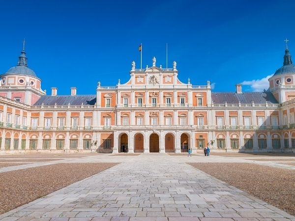 Royal Palace of Aranjuez with colorful architecture, domes, and open plaza in Spain
